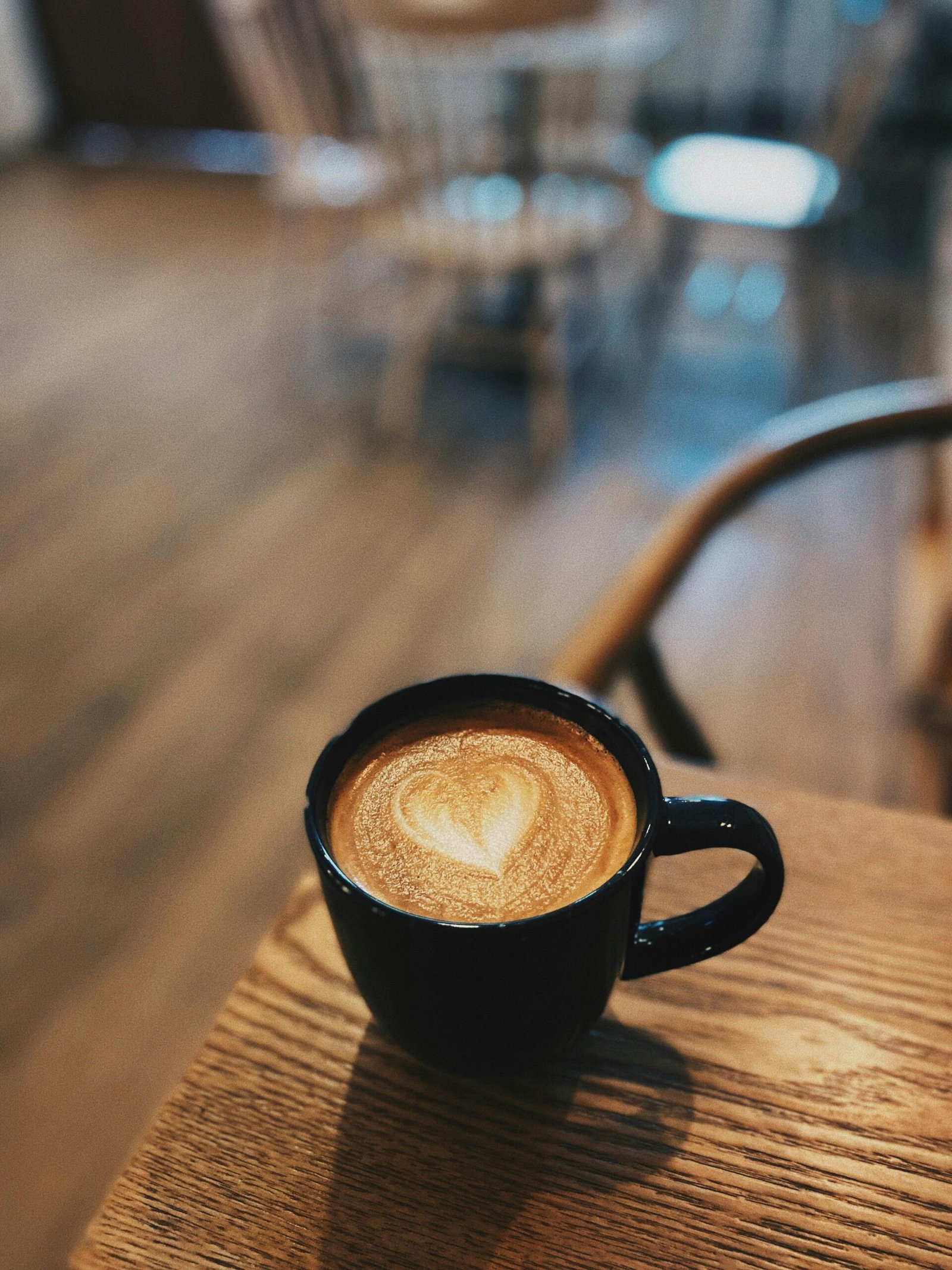 Close-up of heart-shaped latte art in a cozy cafe ambiance. Perfect for coffee lovers.